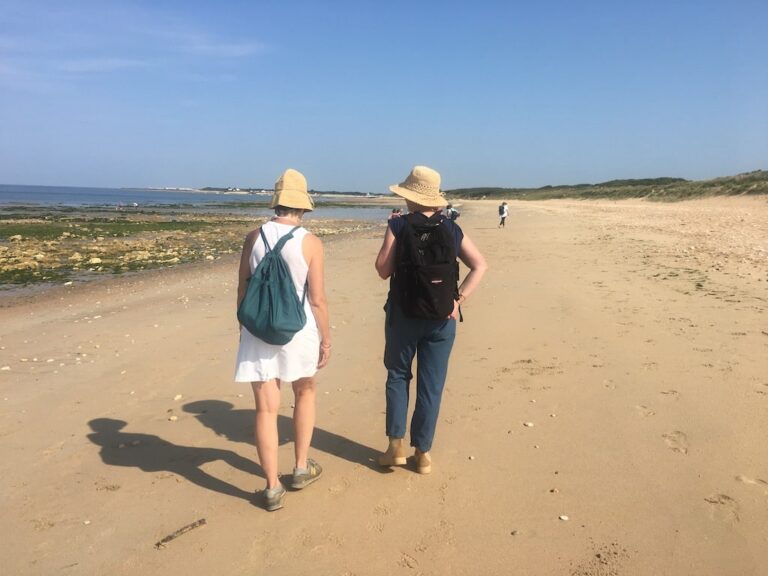 2 personnes marchent sur une plage lors d'une semaine de jeûne et randonnée