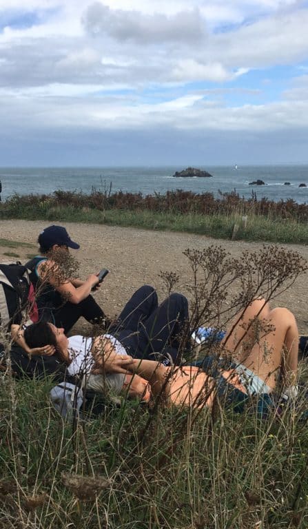 Randonneurs assis sur une plage lors d'un séjour jeûne et randonnée